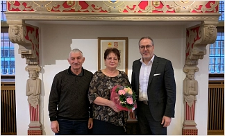 Bürgermeister Helmut Knurbein (rechts) gratulierte Nina Sailer im Beisein ihres Ehemannes zu ihrem 25-jährigen Dienstjubiläum.